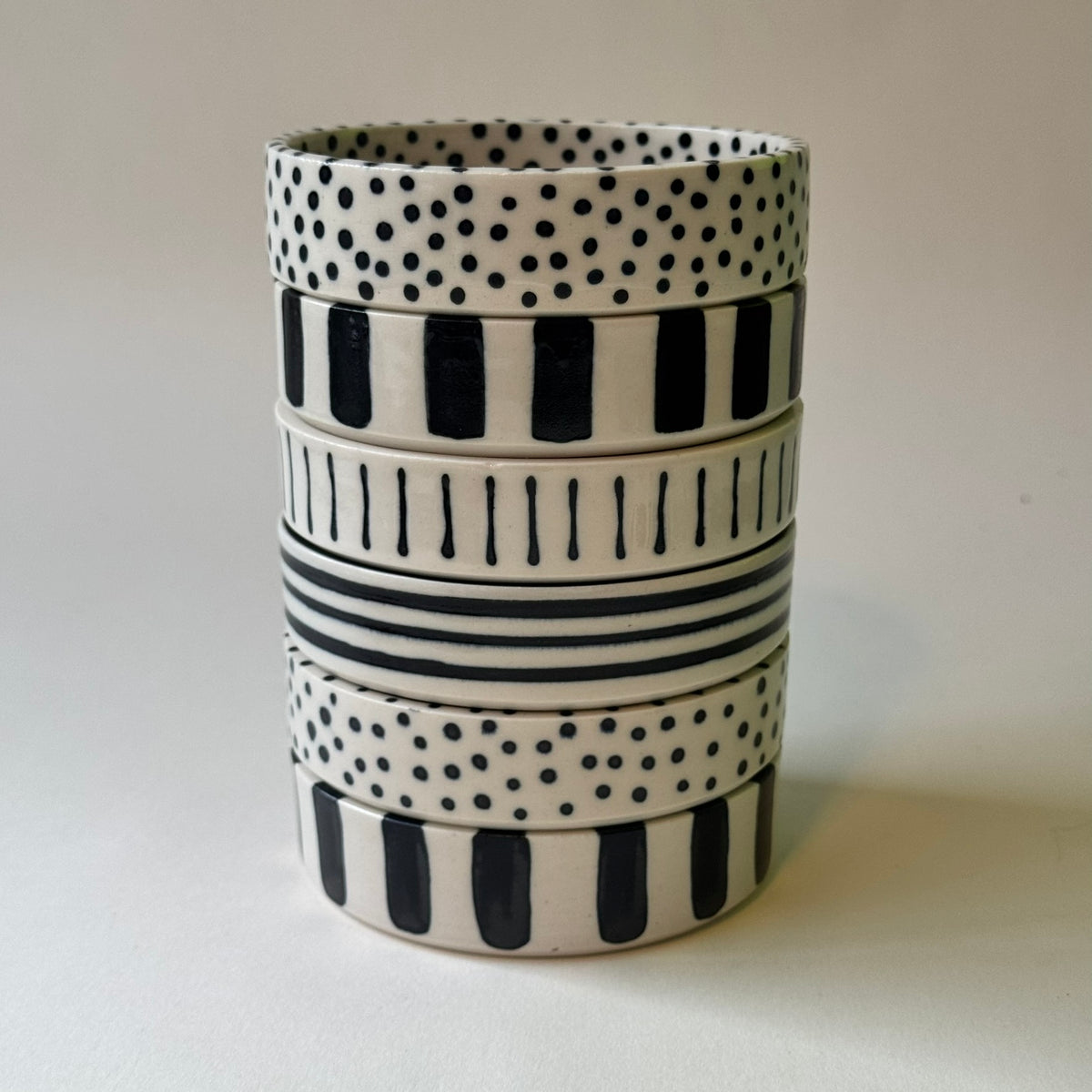 fat med kant som är staplade på varandra med olika design i prickigt och randigt